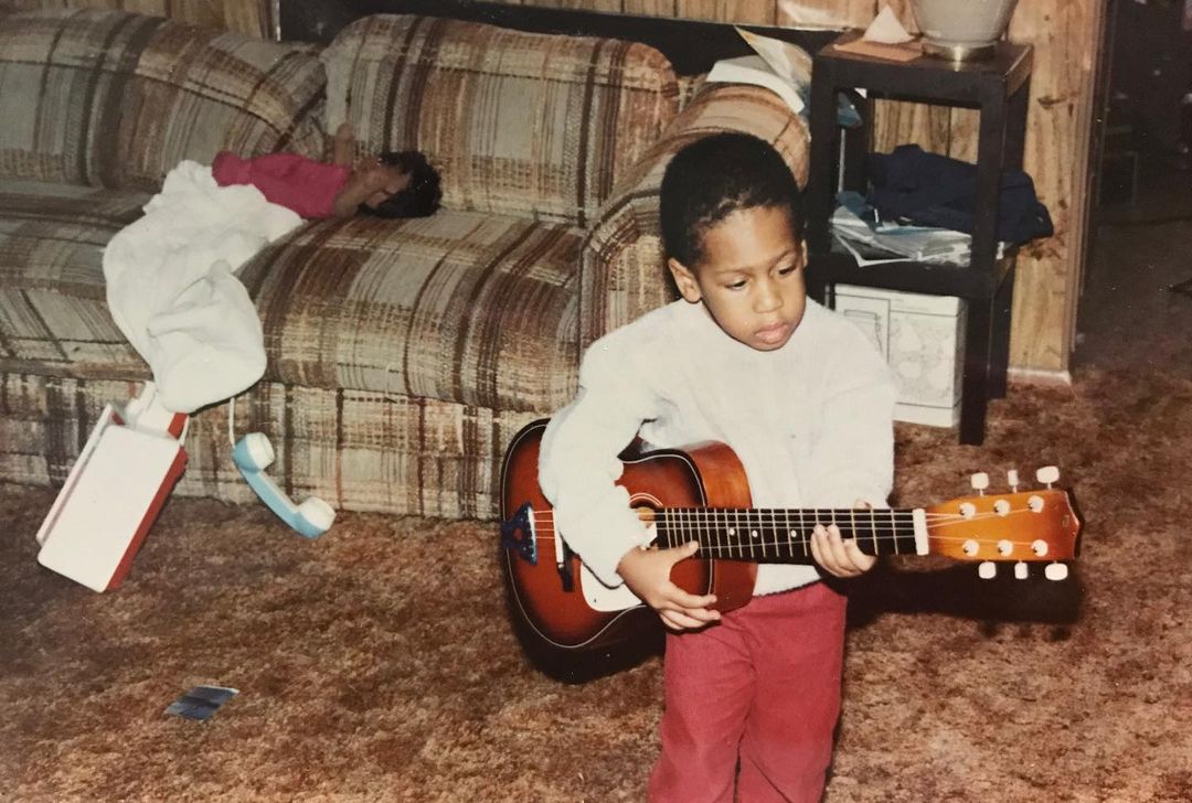 Jon Batiste playing guitar in his childhood days